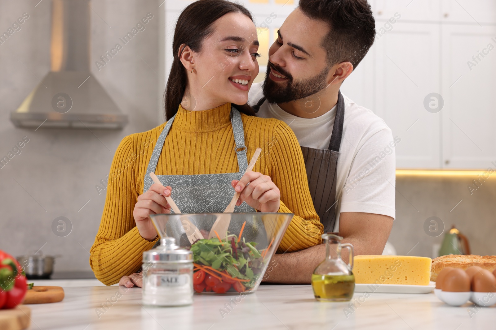 Photo of Lovely young couple cooking together in kitchen