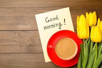 Photo of Beautiful yellow tulips, cup of aromatic coffee and Good Morning note on wooden table, flat lay. Space for text
