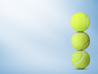 Image of Stack of tennis balls on light blue background. Space for text