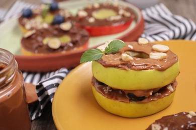 Photo of Fresh apples with nut butter and peanuts on table, closeup