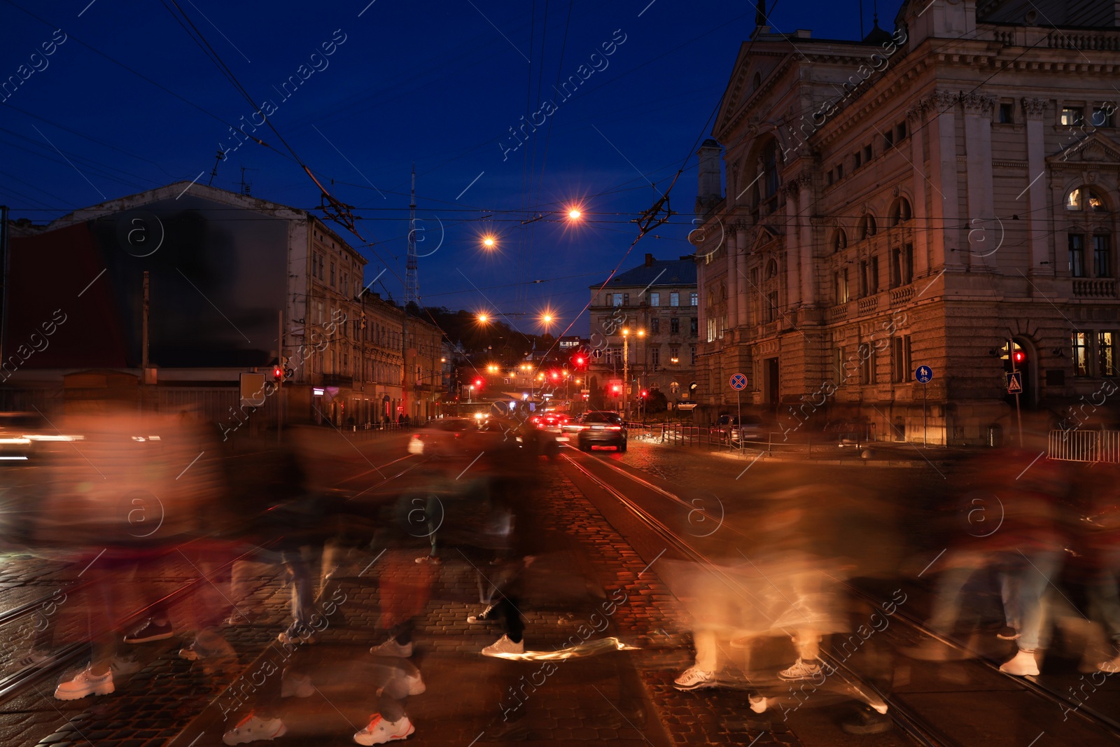 Photo of People crossing city street at night, long exposure effect