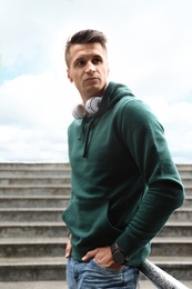 Photo of Portrait of handsome young man with headphones outdoors