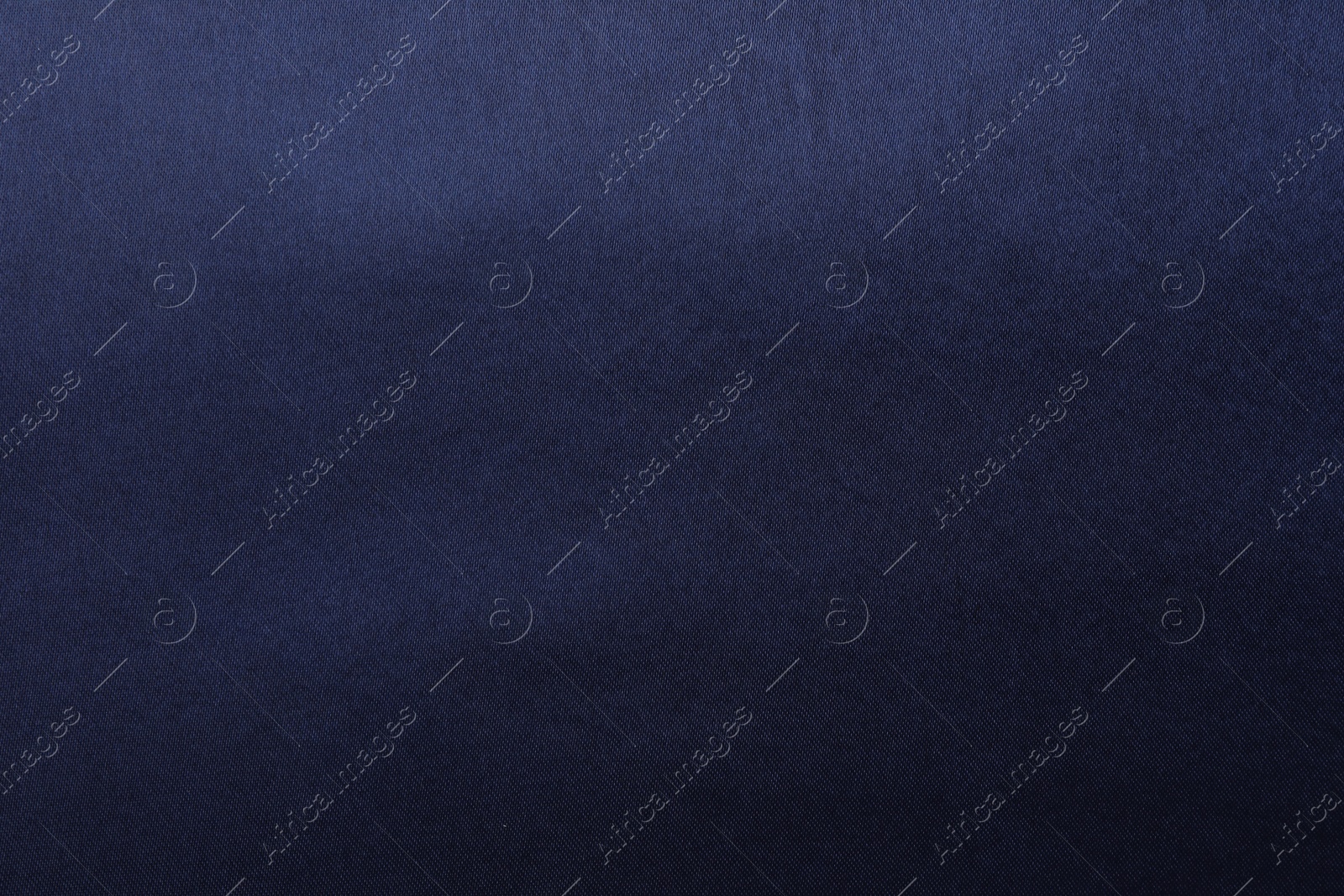 Photo of Texture of dark blue silk fabric as background, top view
