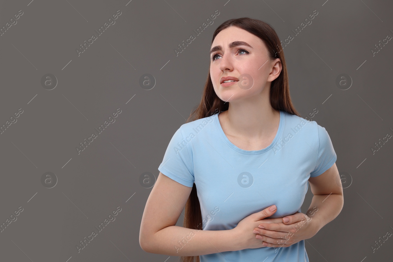 Photo of Woman having heart attack on grey background, space for text