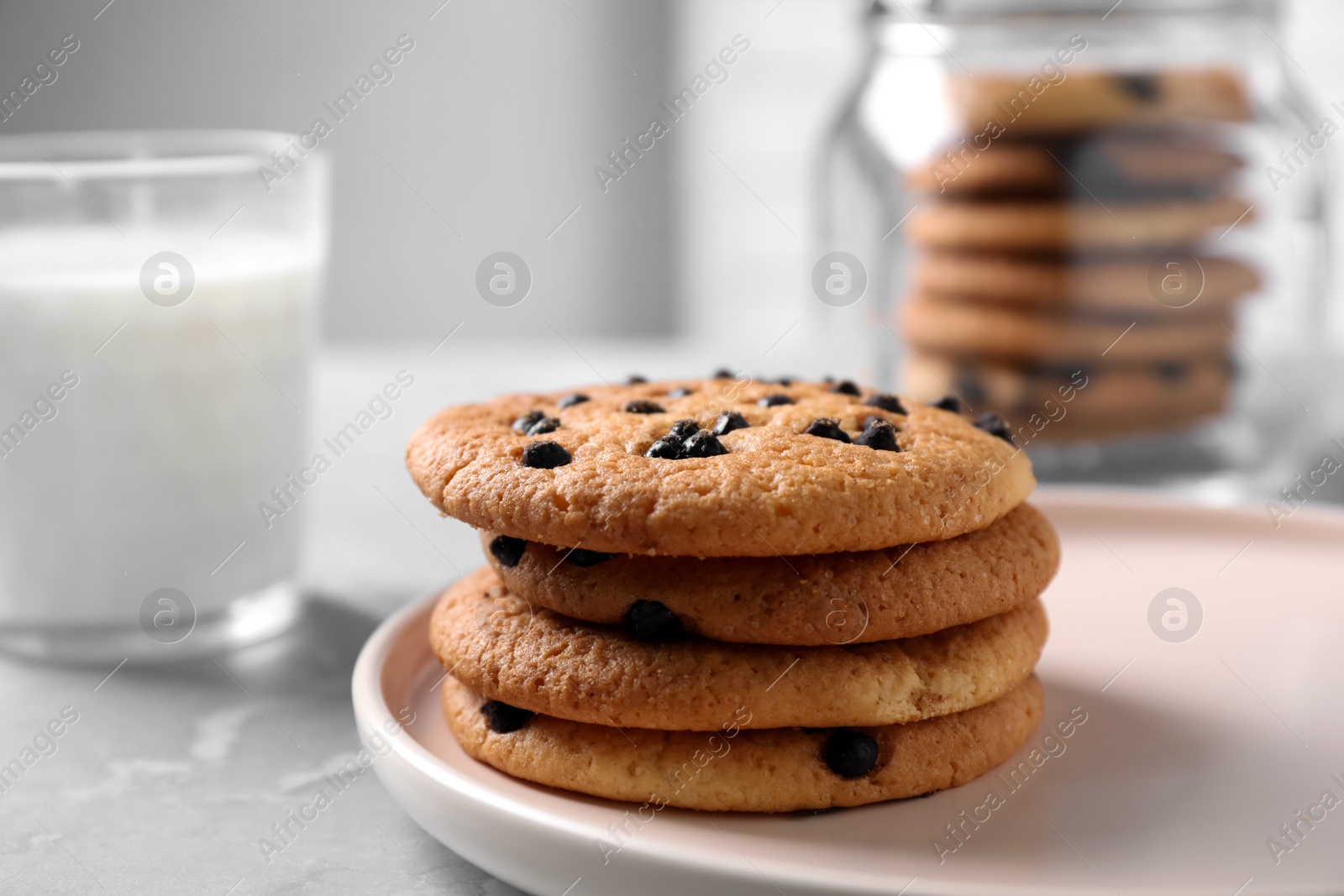 Photo of Delicious cookies with chocolate in plate on light table, closeup. Space for text