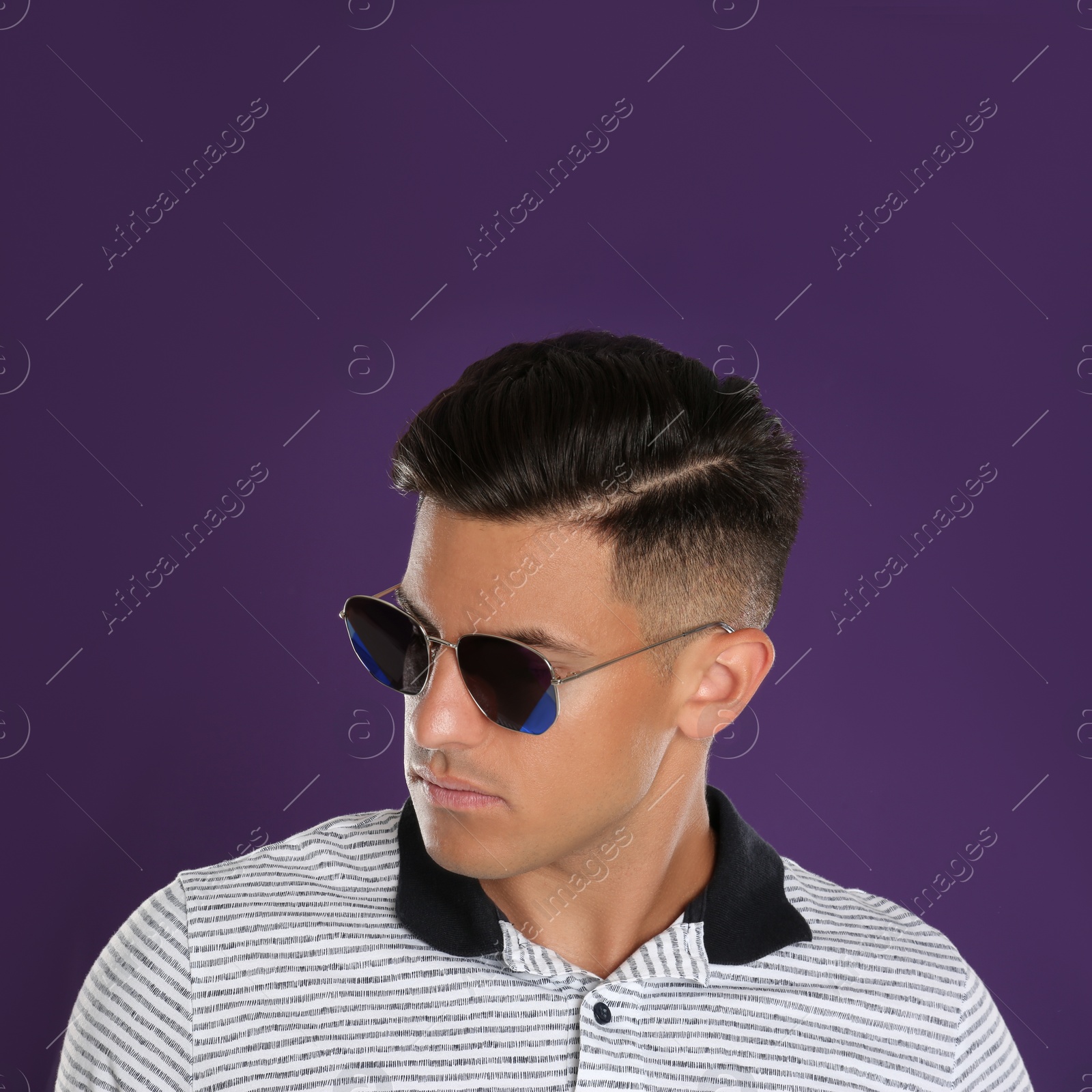Photo of Handsome man wearing sunglasses on purple background, closeup