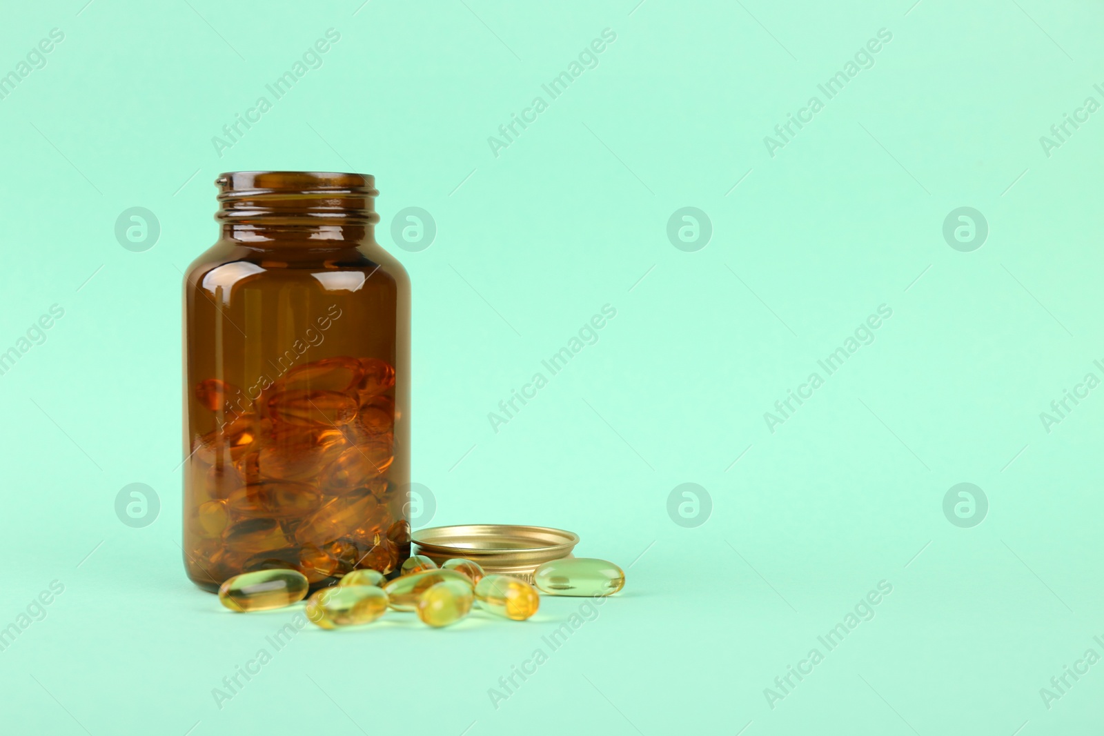 Photo of Jar with vitamin capsules on turquoise background, space for text