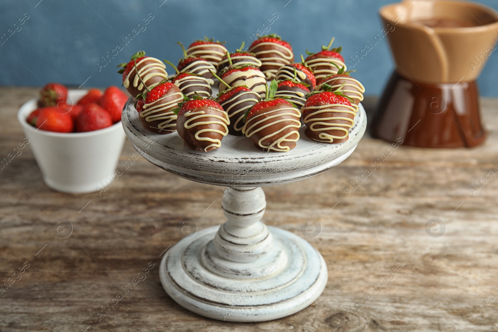 Photo of Dessert stand with chocolate covered strawberries on table