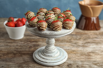 Photo of Dessert stand with chocolate covered strawberries on table