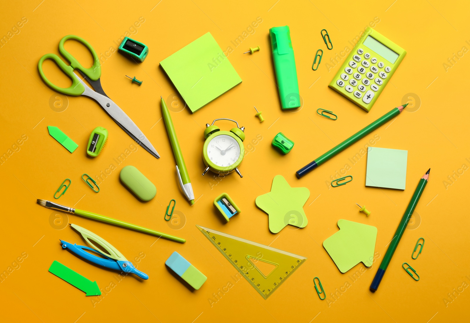 Photo of School stationery on orange background, flat lay. Back to school