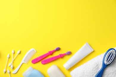 Flat lay composition with baby toothbrushes, toiletries and space for text on color background