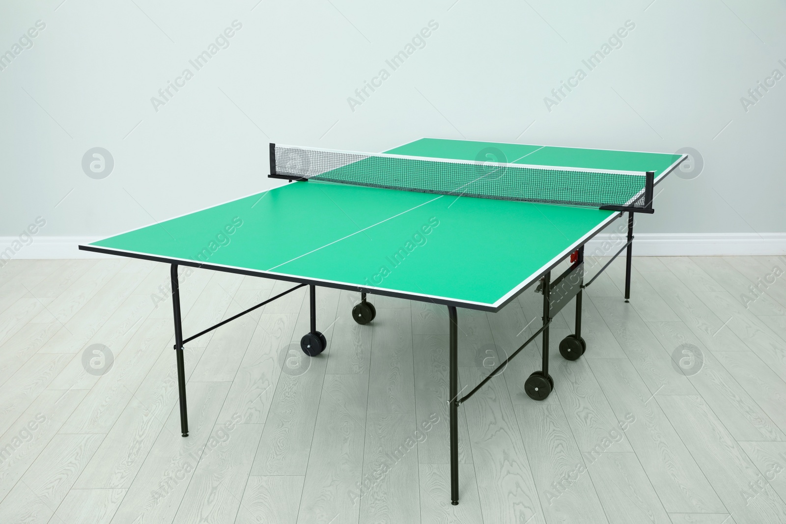 Photo of One green ping pong table with net indoors