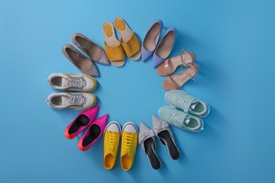 Photo of Different shoes on turquoise background, flat lay with space for text. Diversity concept