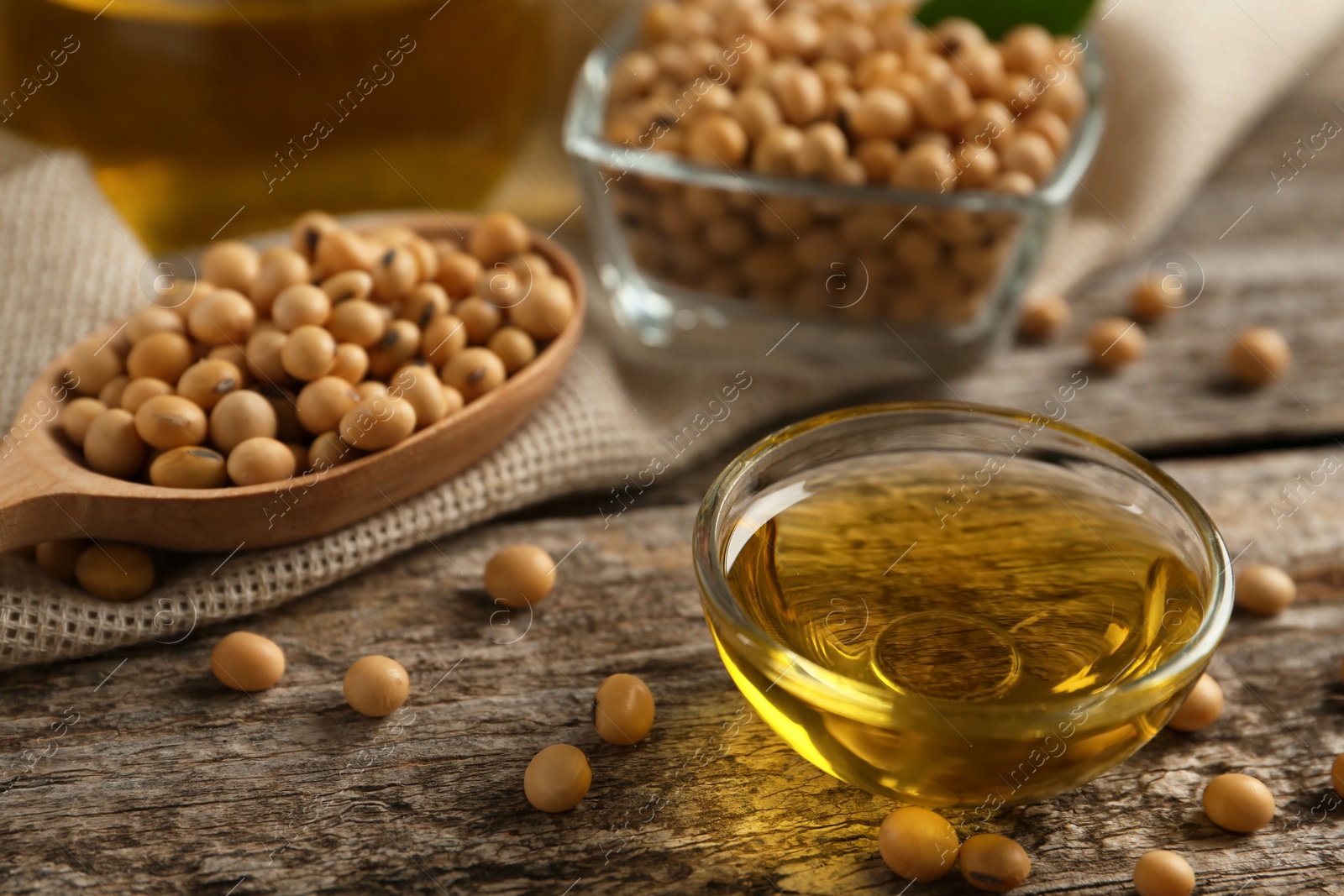 Photo of Composition with soybean oil on wooden table, closeup