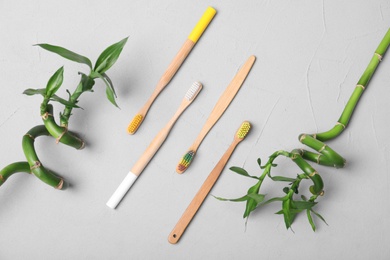 Photo of Flat lay composition with bamboo toothbrushes on grey background