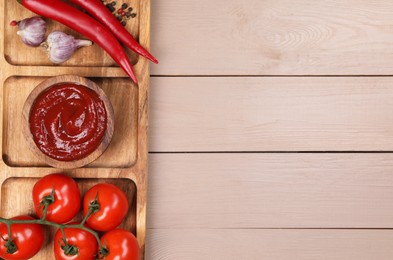 Photo of Plate with delicious ketchup, peppercorns and products on light wooden table, top view with space for text. Tomato sauce