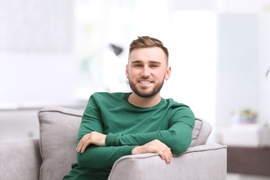 Photo of Portrait of confident young man in armchair
