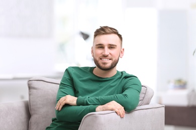 Portrait of confident young man in armchair