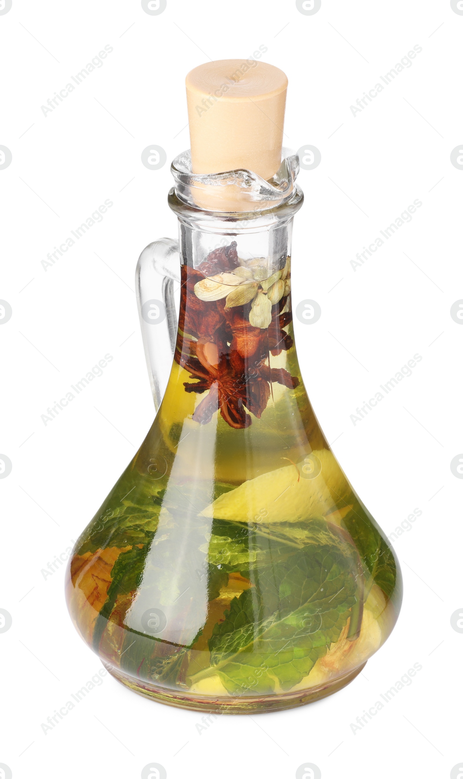 Photo of Glass jug of cooking oil with spices and herbs isolated on white