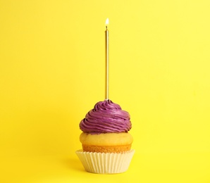 Photo of Birthday cupcake with candle on yellow background