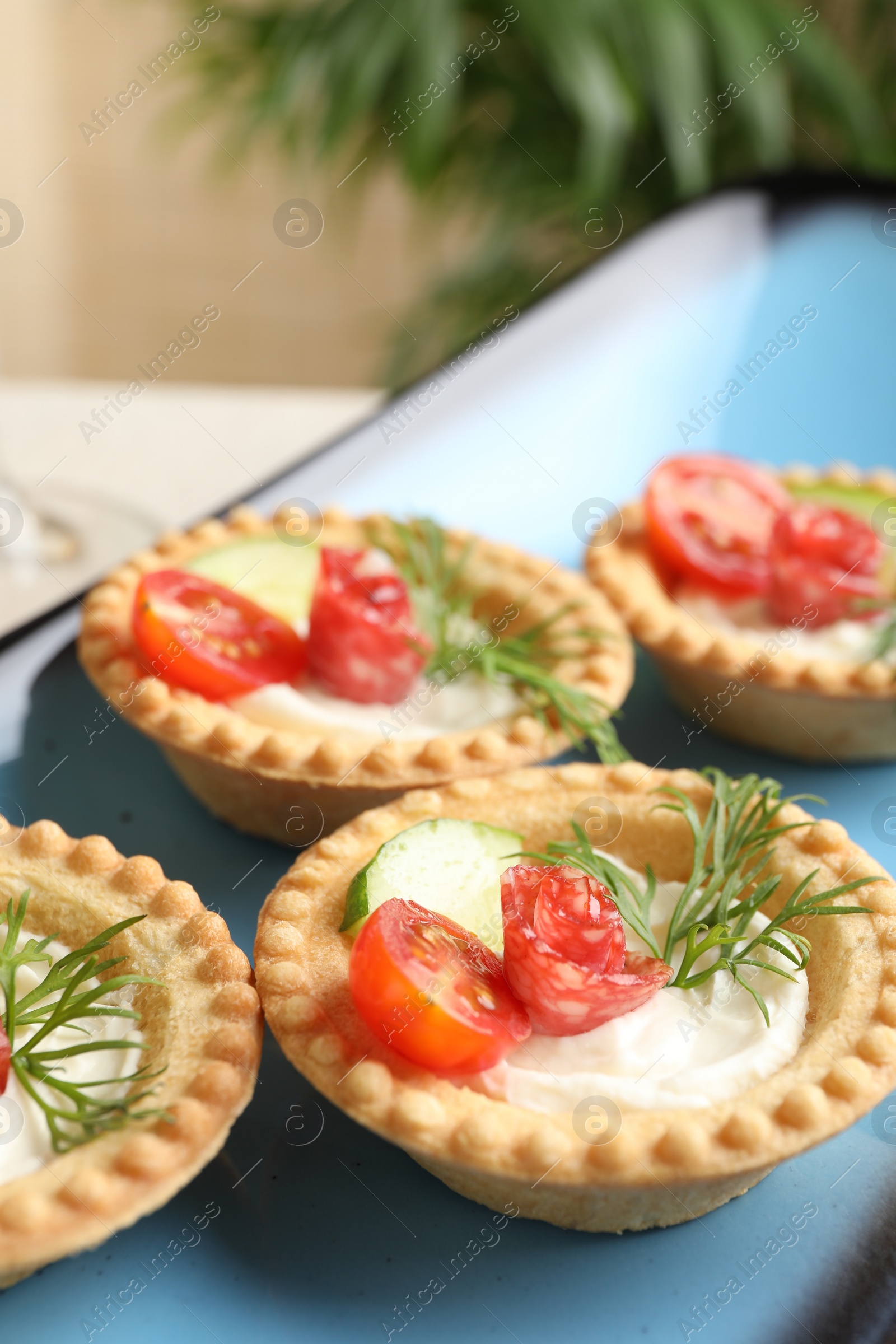 Photo of Delicious canapes with dry smoked sausages, cream cheese and vegetables on table, closeup