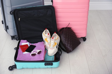 Modern suitcases on light floor. Travelling preparations