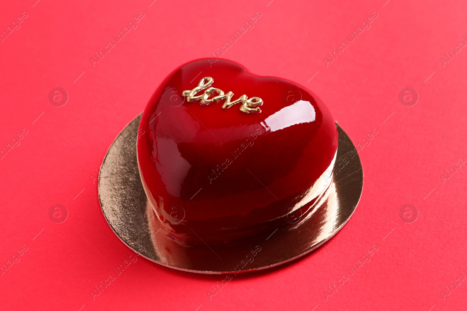 Photo of St. Valentine's Day. Delicious heart shaped cake on red background, closeup