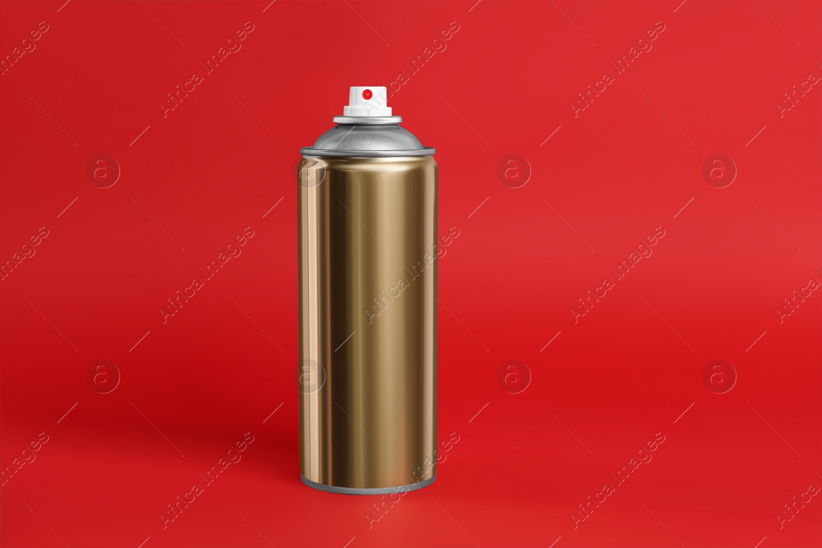 Photo of Golden can of spray paint on red background