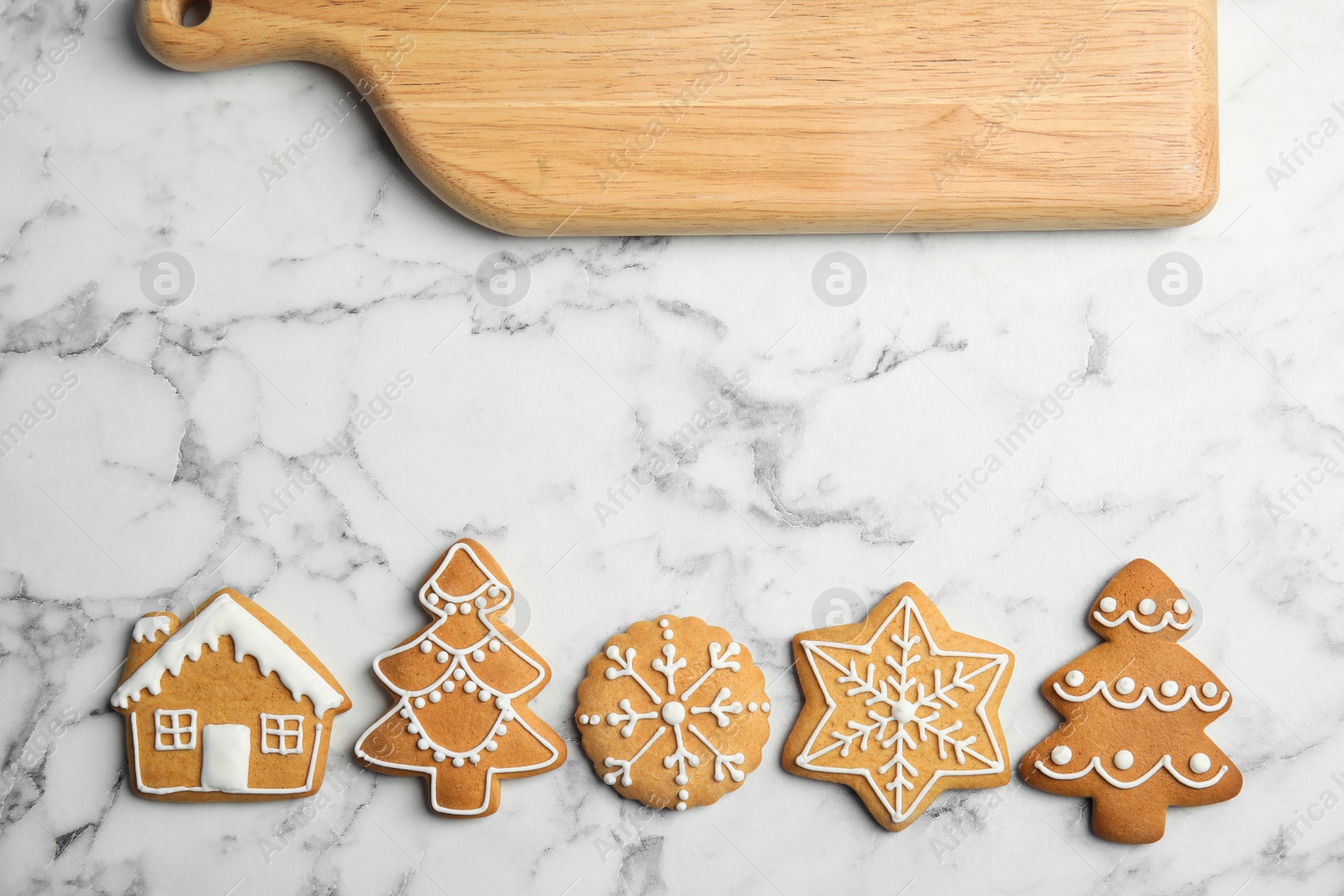 Photo of Tasty homemade Christmas cookies and board on table, top view