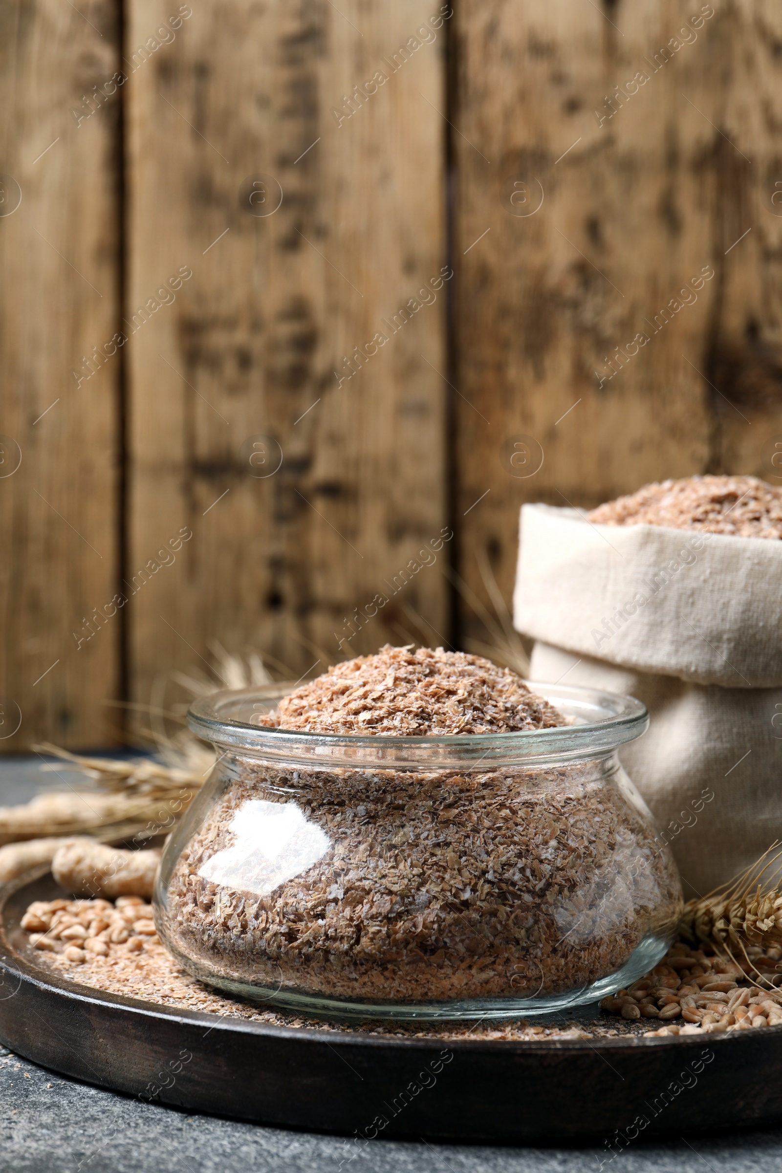 Photo of Jar of wheat bran on grey table