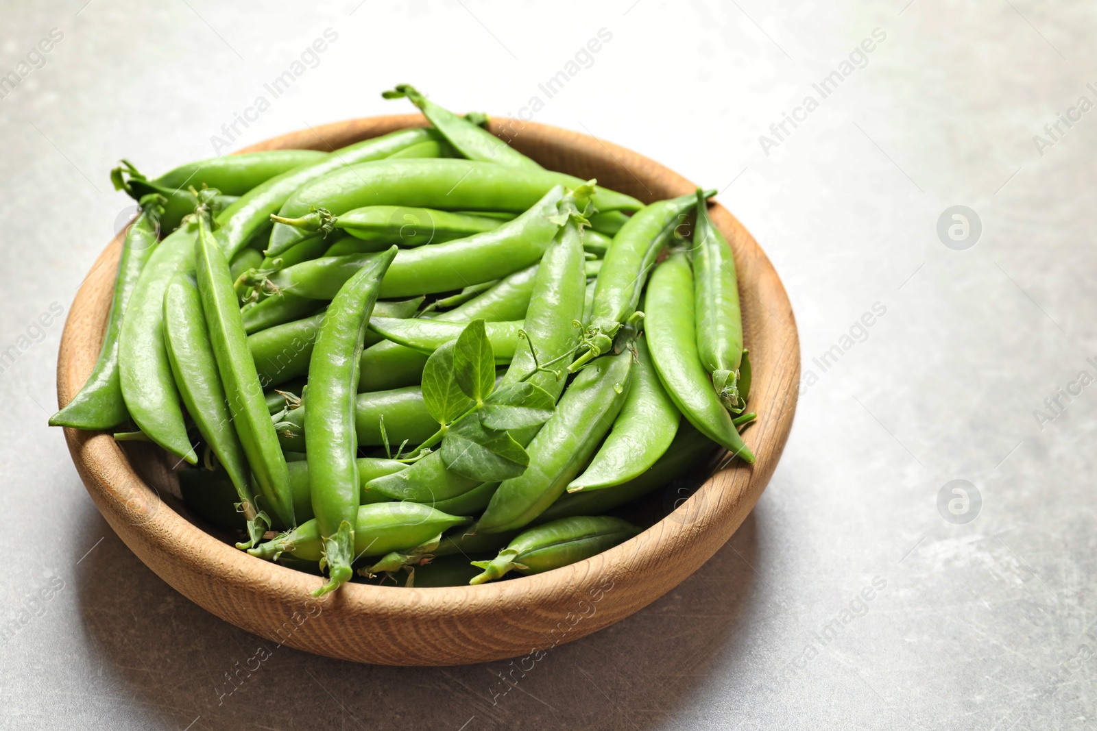 Photo of Plate with green peas on light background