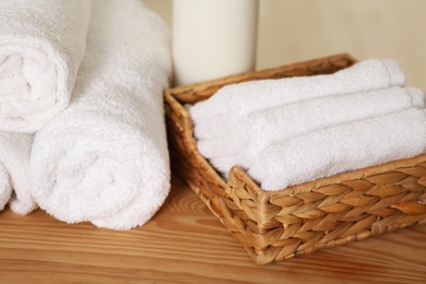 Photo of Soft folded terry towels on wooden table, closeup