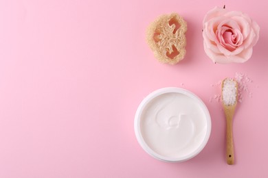 Photo of Jar of cream, sea salt and loofah on pink background, flat lay with space for text. Body care products