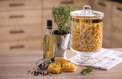 Raw pasta on wooden table in modern kitchen