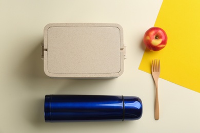 Photo of Thermos, lunch box and apple on color background, flat lay
