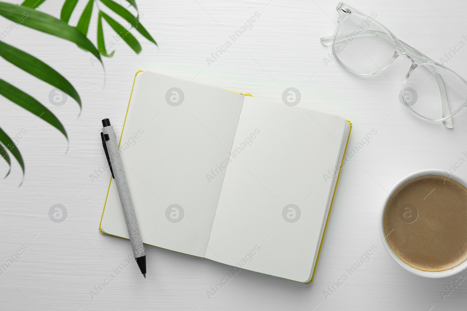 Photo of Open notebook, pen, glasses and cup of coffee on white wooden table, flat lay. Space for text