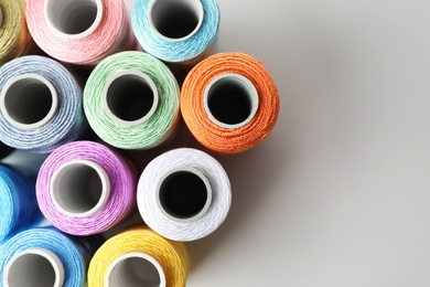 Photo of Color sewing threads on white background, top view