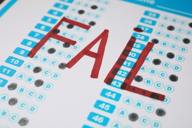 Photo of Word Fail written with red marker on answer sheet, closeup. Student passing exam