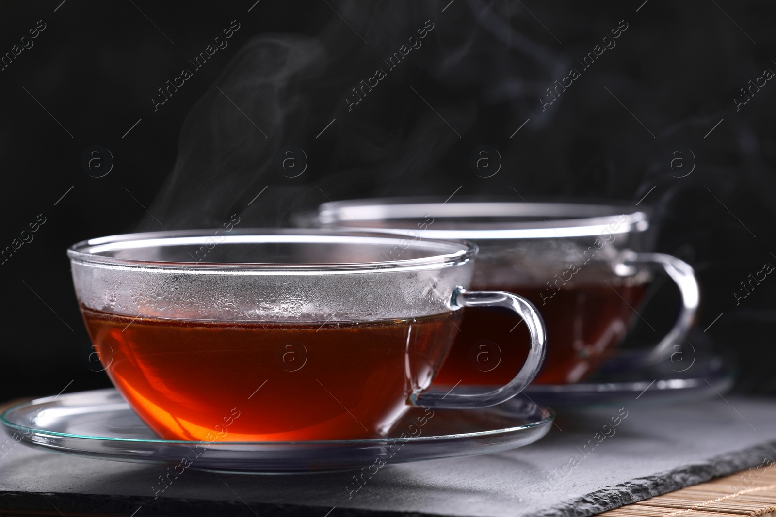 Photo of Aromatic hot tea in glass cups on table, closeup