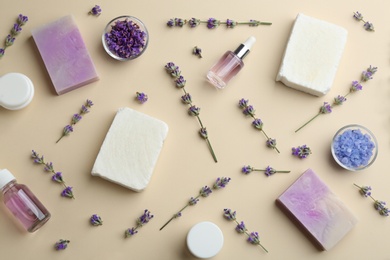 Flat lay composition of handmade soap bars with lavender flowers and ingredients on beige background