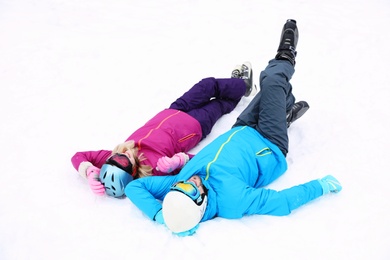 Couple lying on snow at ski resort. Winter vacation