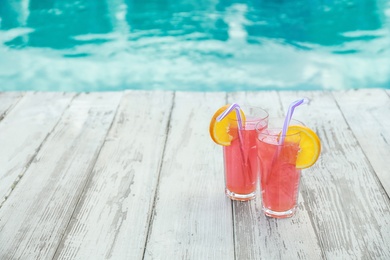 Refreshing cocktails near outdoor swimming pool on sunny day