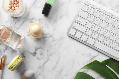 Flat lay composition with keyboard on marble table. Beauty blogger's workplace