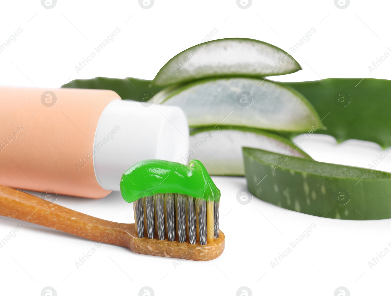 Photo of Toothbrush with toothpaste and green aloe leaves on white background