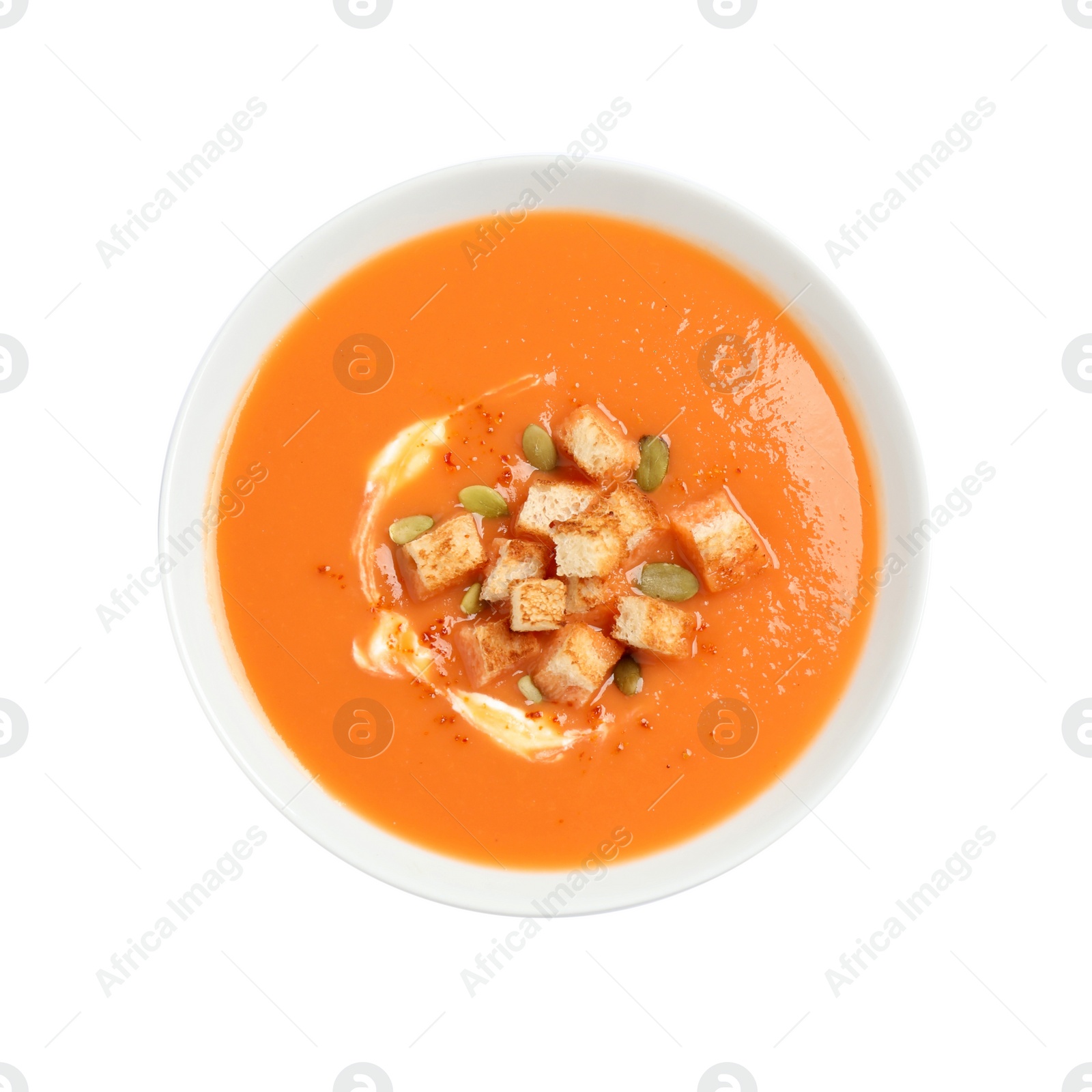 Photo of Tasty creamy pumpkin soup with croutons and seeds in bowl on white background, top view