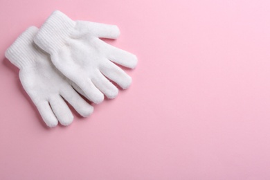 Photo of Pair of stylish woolen gloves on pink background, flat lay. Space for text