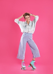 Young woman with retro roller skates on color background