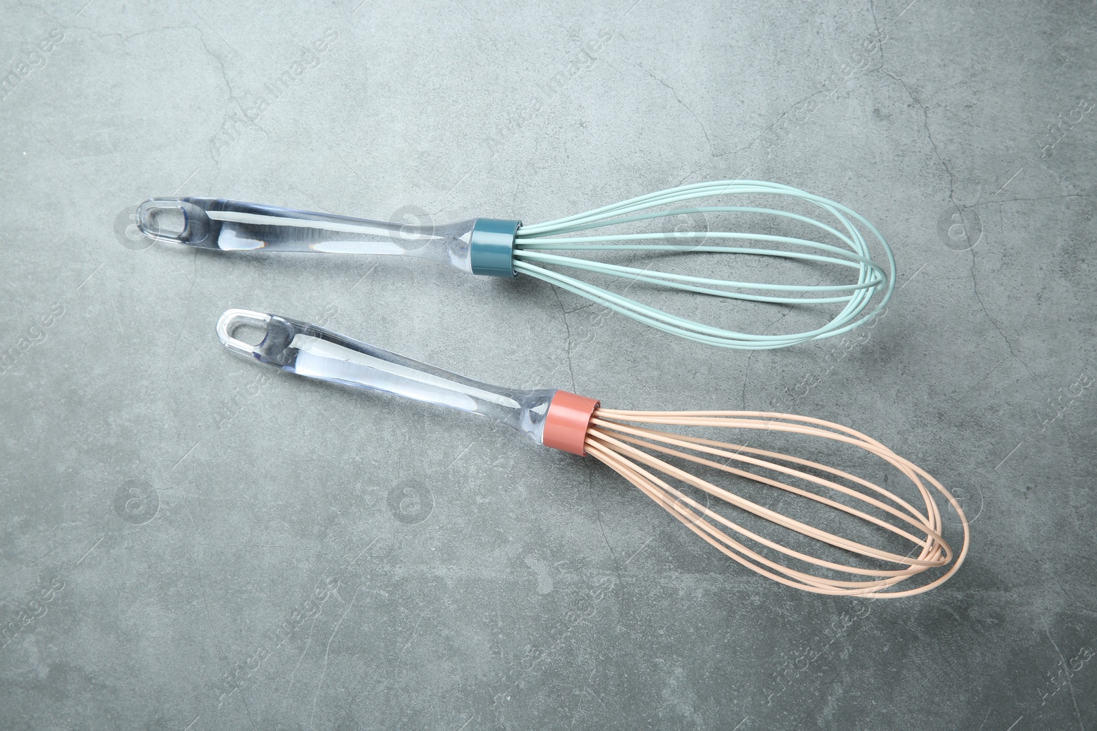 Photo of Two whisks on gray table, top view