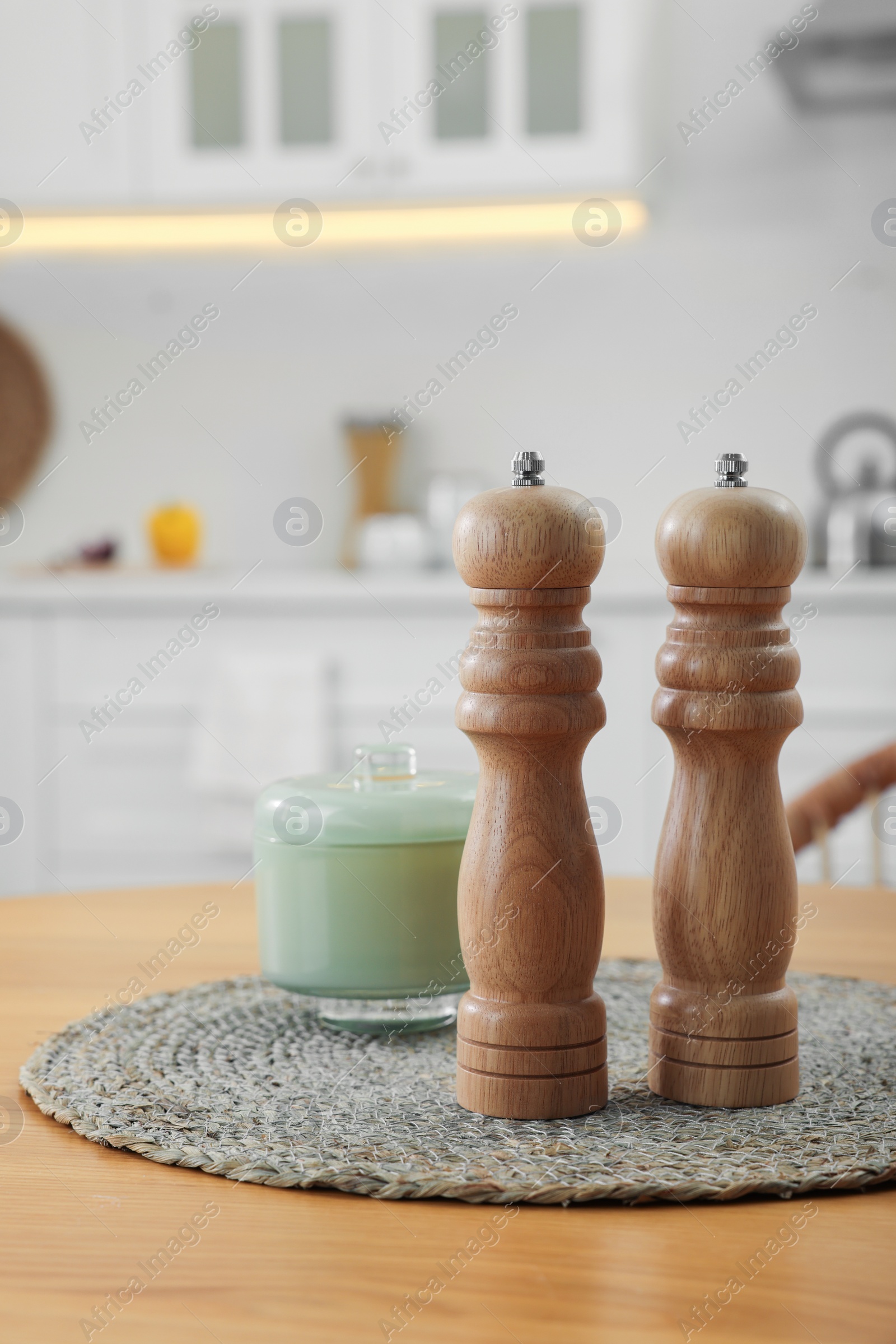 Photo of Wooden salt and pepper shakers on table in kitchen, space for text