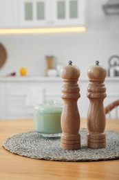 Wooden salt and pepper shakers on table in kitchen, space for text